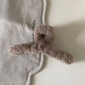 Detailaufnahme der weichen Plüsch-Haarklammer in Graubraun für winterliche Frisuren