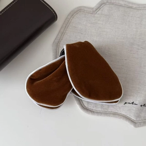 Detailed macro view of dark brown velvet texture and white piping edge on a travel hair clip