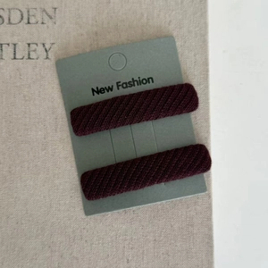 Set of two elegant burgundy twill fabric wrapped hair clips on minimalist packaging