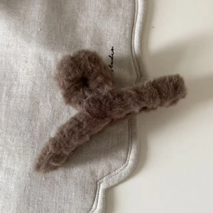 Detailaufnahme der braunen Plüsch-Haarklammer aus Kunstkaninchenfell auf weichem Stoff