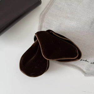 Macro detail of large velvet triangle shark hair clip with elegant dark brown fabric texture