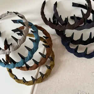 Dettaglio di cerchietti antiscivolo con denti in tessuto a maglia vintage in colori Morandi