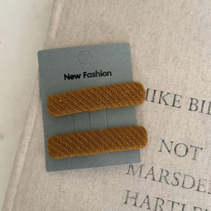 Close-up of caramel brown knit texture BB hair clips on a premium paper display card