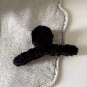 Detail einer flauschigen schwarzen Haarklammer aus Kunstpelz für elegantes Winterstyling