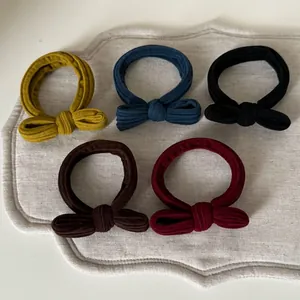 Set of vintage bow hair scrunchies in five colors made of ribbed knit fabric texture