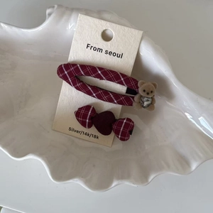 Détail de barrettes à carreaux rouges avec ours floqué et strass en forme de cœur