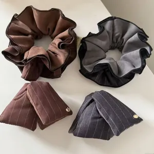 Detailed view of large striped scrunchies and bow clips in brown and grey colors