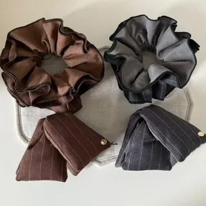 Detailed view of striped fabric scrunchies and bow hair clips with gold metal accents