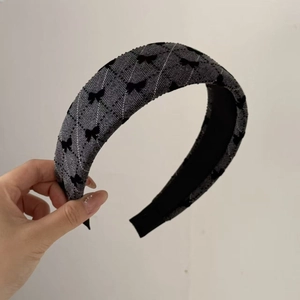 Padded headband featuring grey plaid pattern and black bow motifs for women