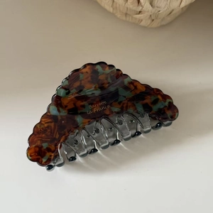 Detail of French acetate hair claw clip showing tortoise shell pattern and metal spring
