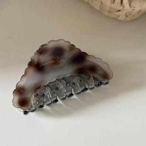 Detailed macro view of marbled acetate hair claw clip with Barrette La France gold lettering