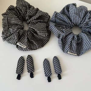 Detail view of plaid scrunchies and matching hair clips set in black and blue patterns