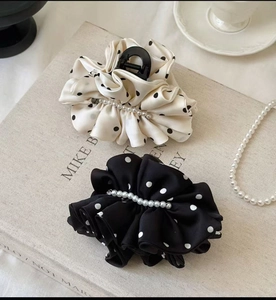 Détail de grandes pinces à cheveux en satin à pois avec perles blanches élégantes