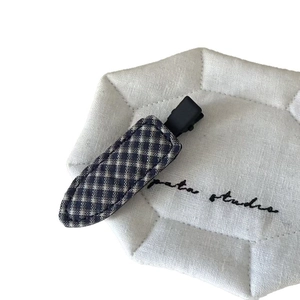 Plaid fabric hair clip in vintage dark blue and brown on a white quilted display pad