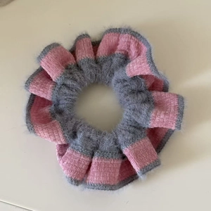 Detail shot of pink and gray striped knit scrunchie with soft fuzzy texture