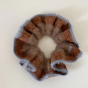 Detail of caramel knit scrunchie with fluffy grey faux fur trim for winter hairstyles