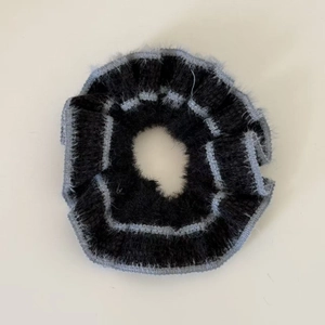 Close-up of bicolor grey and black fuzzy knit hair scrunchie with plush texture