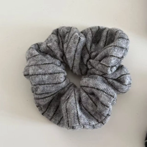 Grey striped knitted scrunchie with soft fabric texture for elegant hair styling