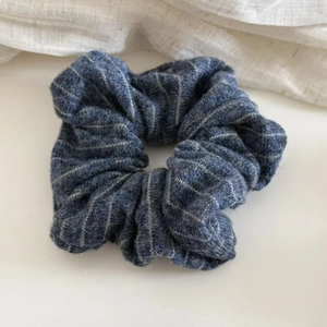 Detailed view of dark blue striped knit scrunchie with soft textured fabric