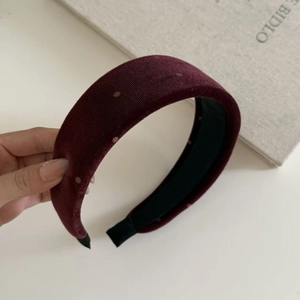 Detailed macro of burgundy velvet sponge headband with classic white polka dots texture