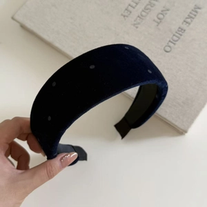 Detailed close-up of dark blue velvet headband with polka dots and non-slip inner lining