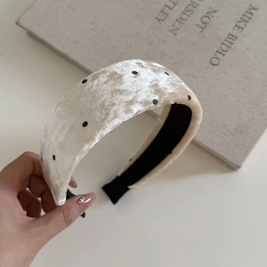 Close-up of beige velvet wide headband with black polka dots and anti-slip lining