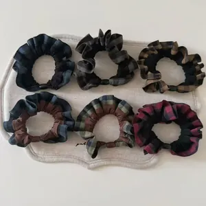 Close-up of 6-piece plaid scrunchies set with ruffled edges in classic checkered patterns