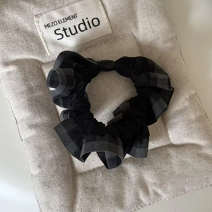 Classic black and grey plaid fabric scrunchie with soft ruffled texture for women