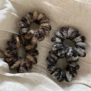 Détails de quatre élastiques à cheveux pelucheux à motif léopard sur tissu beige