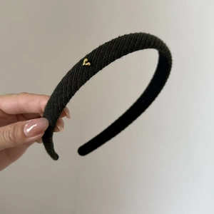 Minimalist black knitted headband with a small gold heart metal ornament for women
