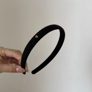 Black knitted headband with gold heart metal accent for women in elegant rib knit style