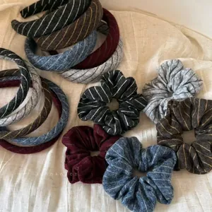 Striped knit scrunchies and headband set in various dark colors on a soft fabric backdrop