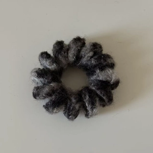 Détail rapproché du chouchou en fausse fourrure pelucheuse avec texture gris et noir