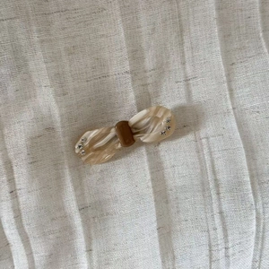 Vintage acetate bow hair clip with white marble texture and sparkling rhinestone accents