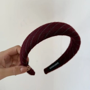 Detailed macro of a handmade burgundy striped knit headband with a textured sponge padding