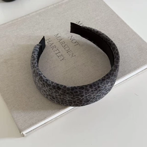 Macro detail of leopard print headband texture on linen book background with anti-slip lining