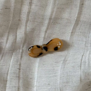 Close-up of vintage acetate tortoiseshell bow hair clip with sparkling white rhinestones