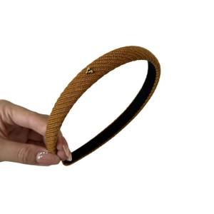 Caramel knitted headband with golden heart charm in a warm minimalist winter style