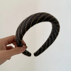 Detail of dark grey striped knit padded headband with soft wool-like texture