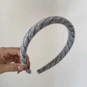 Detail of grey knitted headband with black stripe pattern showing premium fabric texture