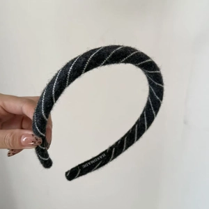 Macro detail of handmade thick wool knit headband featuring grey striped texture
