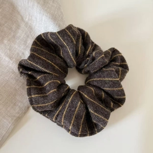 Close-up of retro striped knit scrunchie in coffee brown with soft pleated texture