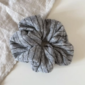 Detail shot of gray striped knitted fabric texture on an elastic oversized scrunchie