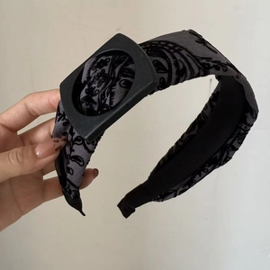 Close-up of retro paisley pattern fabric headband with black square buckle detail