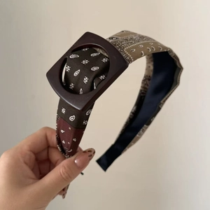 Detail of paisley print headband with retro brown fabric and stylish resin buckle