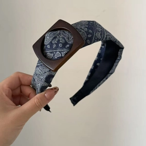 Detail of blue paisley headband with denim texture and vintage brown square buckle