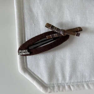 Detail of handmade plaid bow hair clip featuring a France engraved silver metal plate