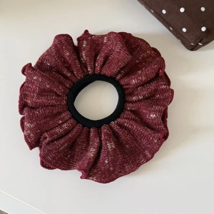 Close-up of knit scrunchie with burgundy and white oil painting texture and ruffle detail