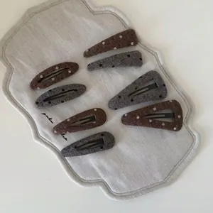 8-piece set of minimalist polka dot pattern hair clips in earth tones and grey wool fabric