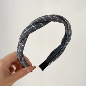 Detail of grey windowpane plaid headband featuring a twisted knot and inner plastic teeth